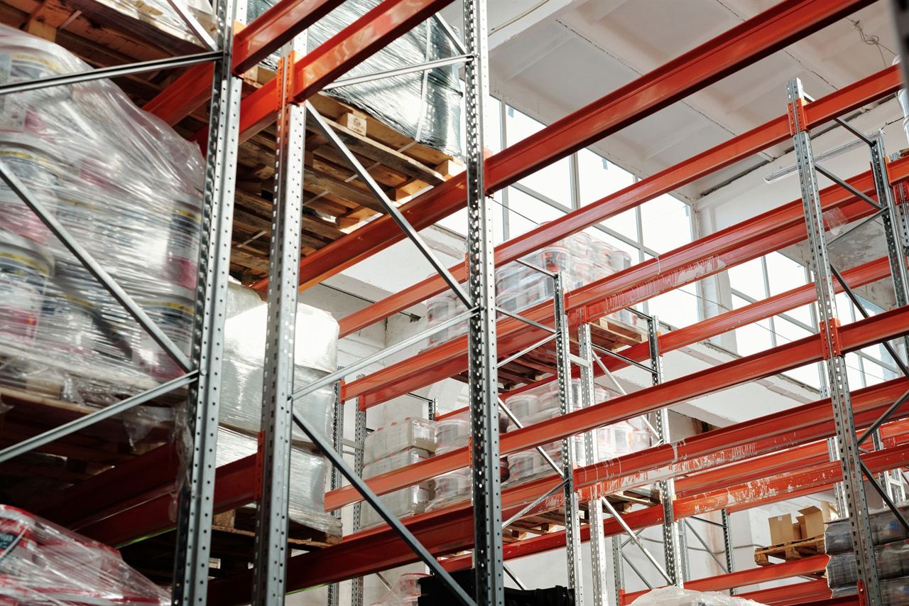 Warehouse racks with pallets under white windows