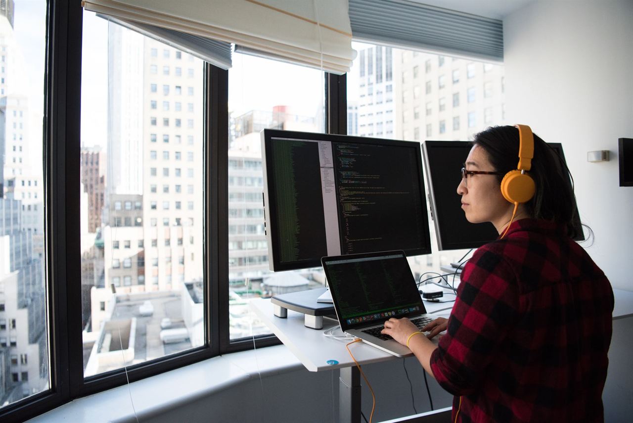 A developer working at a desk with two monitors