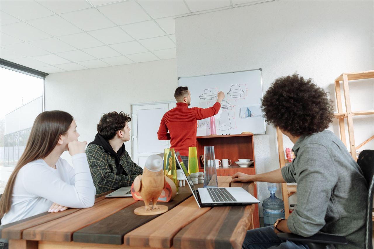 A team discussing a whiteboard in a bright workspace