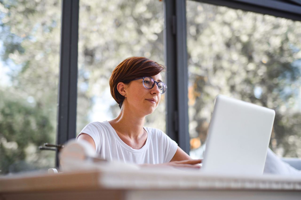 A person working on a laptop in a bright room